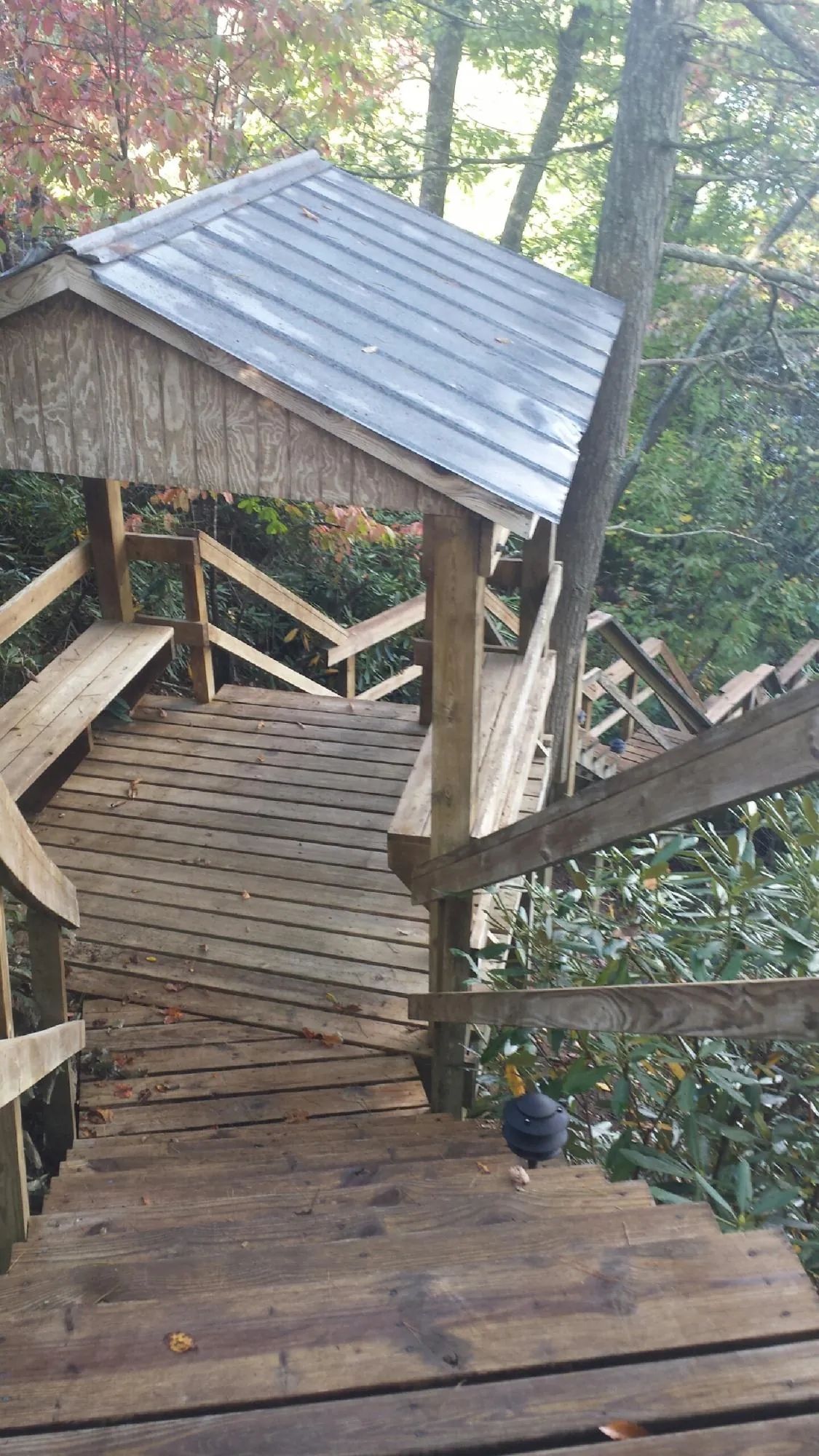 Metal roofed shelter over wooden steps on a wooded walkway — Skylight Repair & Installation work by our crew in Princeton